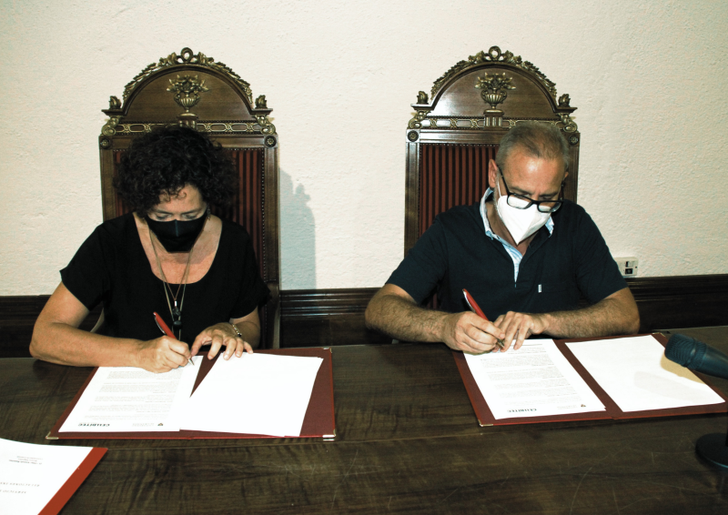 Firma UGR Cellbitec Dos personas sentadas firmando sobre un papel